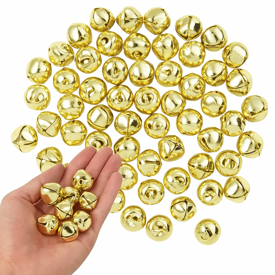 Gold jingle bells on a white background with a hand holding some of them.