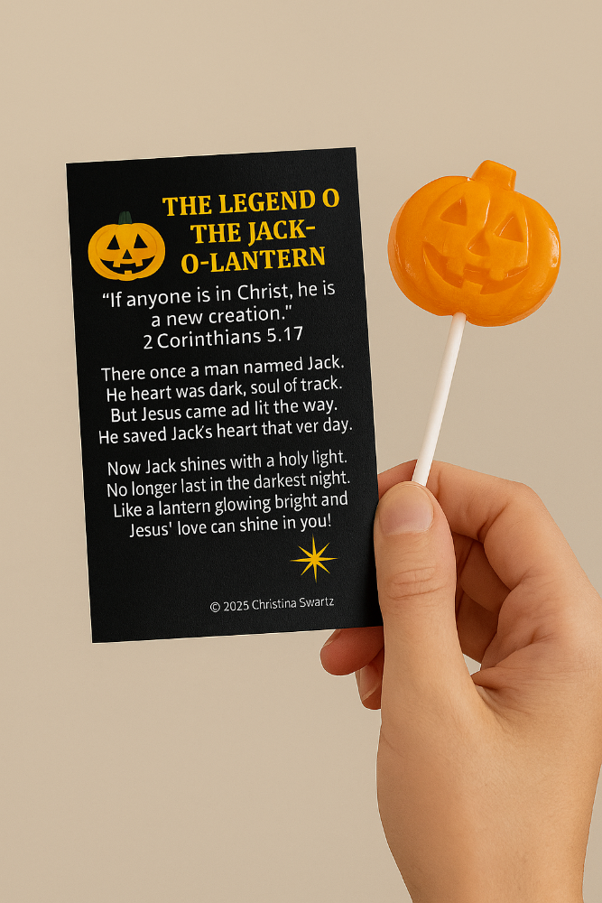 Hand holding a Christian Jack-O’-Lantern lollipop with scripture card from 2 Corinthians 5:17