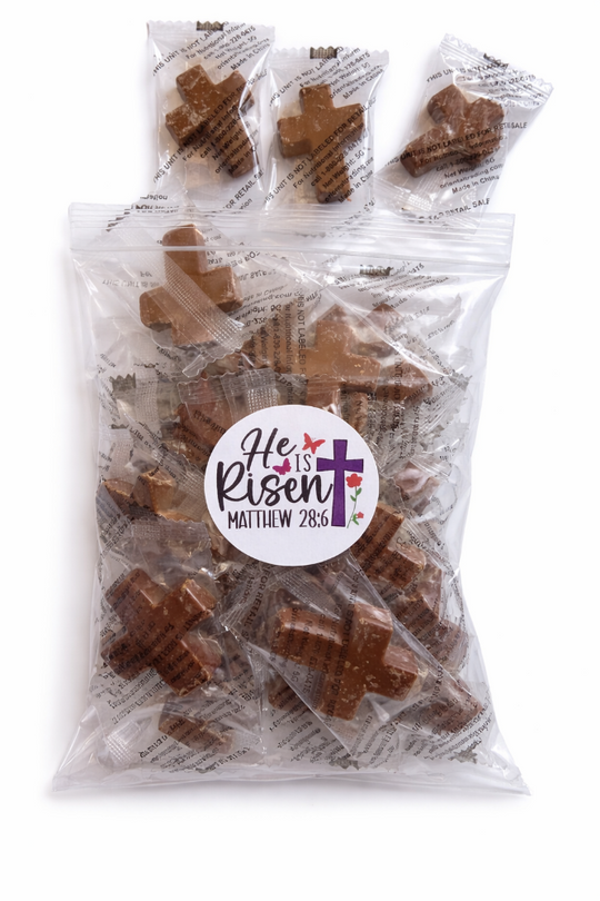 Packaged chocolate crosses with a 'He is Risen' label on a white background