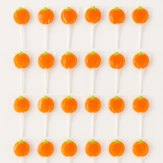 Pumpkin-shaped lollipops on white sticks arranged in rows.