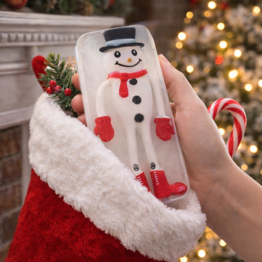 Hand holding a snowman toy embedded soap with a Christmas tree and stocking in the background
