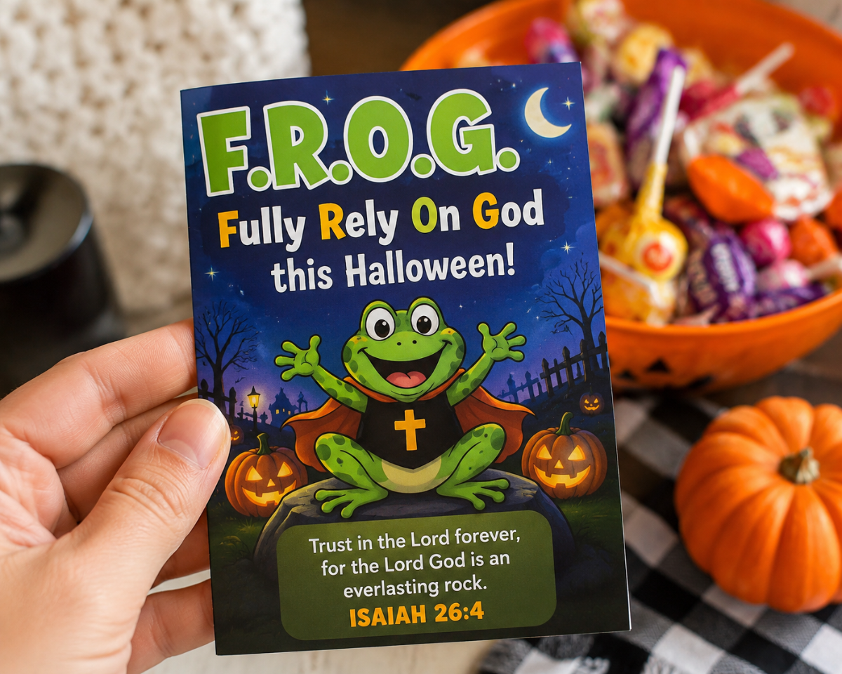 A hand holds a Halloween-themed gospel bible tract that reads 'F.R.0.G. fully rely on God this Halloween. Bulk 100 count for trunk or treat events.