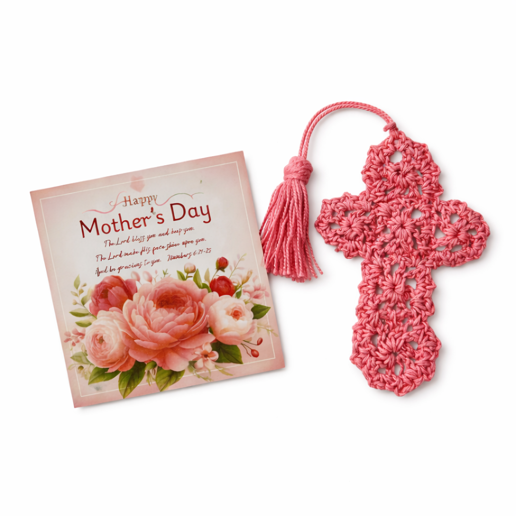 Pink crocheted cross with tassel next to a 'Happy Mother's Day' card on a white background